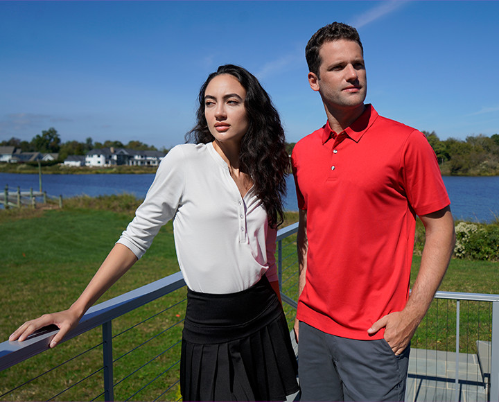 A pair of models wearing polo shirts on a sunny day.
