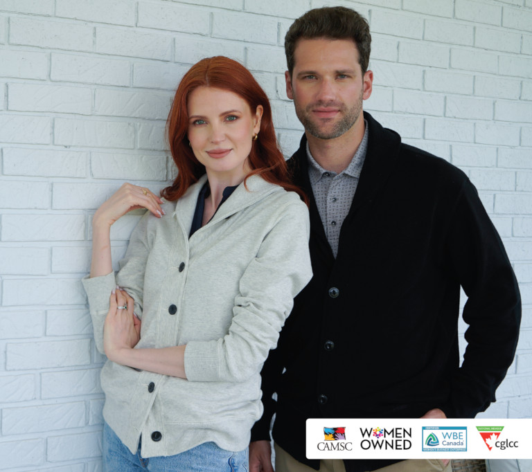 A woman and a man wearing grey and black Redwood sweaters.